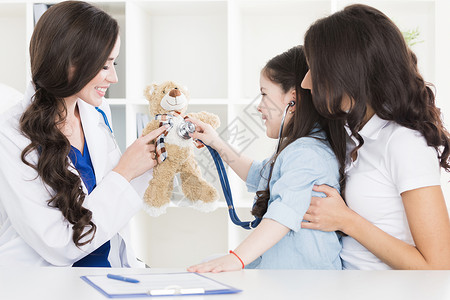 儿科医生孩子儿科医生检查小女孩泰迪熊的心跳图片