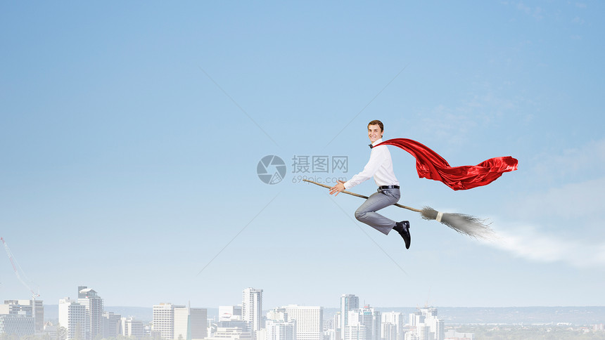 男人骑扫帚轻的商人高空的扫帚上飞翔图片