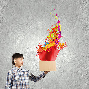 创造思维小男孩纸箱里溅出五颜六色的油漆背景图片