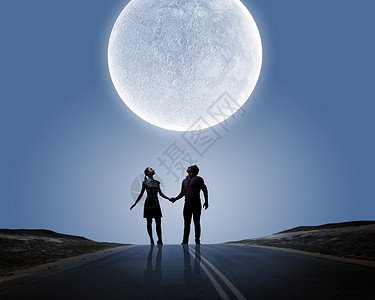 浪漫的站月光下的轻浪漫夫妇的剪影调情高清图片素材