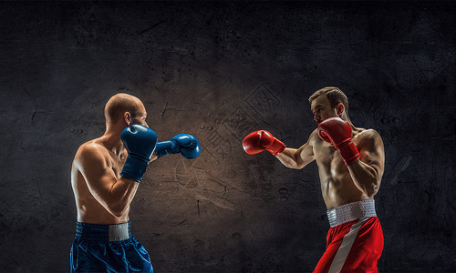 拥力量耐力两个强壮的拳击手戴着手套抗水泥墙背景图片