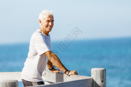 穿着运动服站海滩上的男人站海滩上的男人穿着运动服,看来既健康又快乐图片