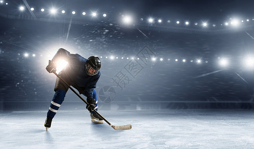 溜冰场的冰球运动员冰球运动员溜冰场的灯光下图片