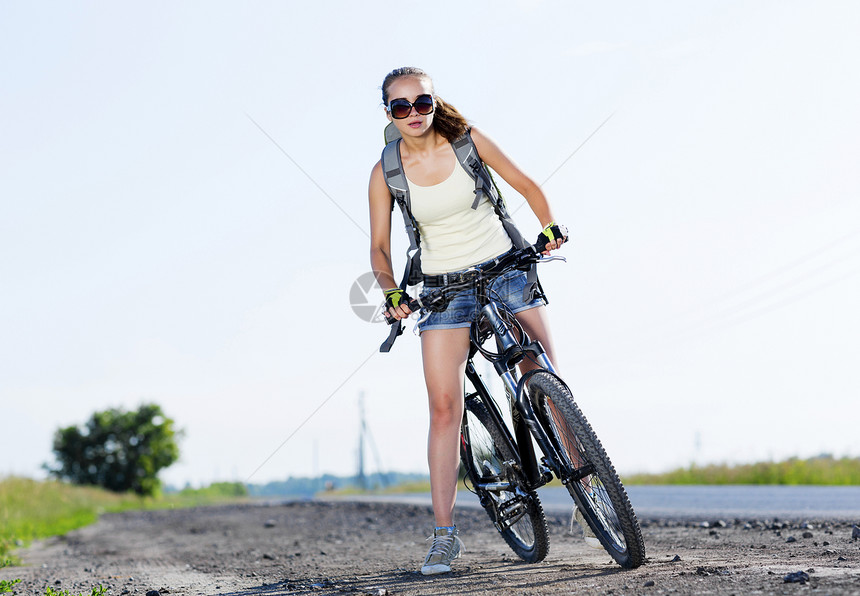 轻漂亮的女人路上骑自行车夏季自行车步行图片