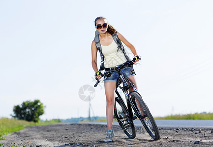 轻漂亮的女人路上骑自行车夏季自行车步行图片