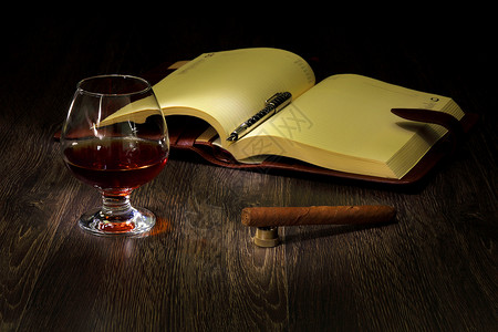杯白兰地,雪茄本旧书附近背景图片