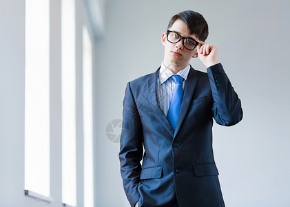 轻成功的商人戴眼镜的英俊自信的商人的形象图片