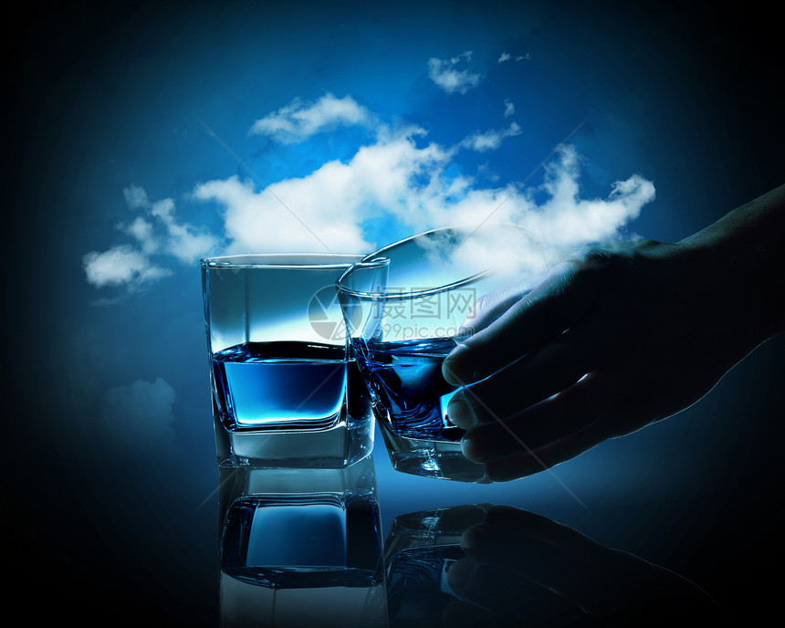 两杯蓝色液体两杯蓝色液体多云的背景下图片