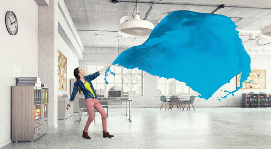 女人拉蓝色的布料办公室里的轻女人拉着蓝色的空白物背景图片