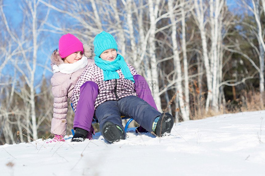 冬天的乐趣两个可爱的女孩美丽的雪冬公园里享受雪橇图片