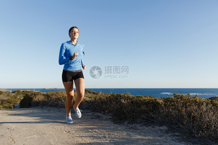 运动跑步者海滩上慢跑锻炼适合女健身模型沿海洋慢跑图片