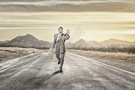 男人跑着伸手轻尖叫的商人沥青路上奔跑图片