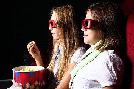 两个轻女孩电影院看电影图片