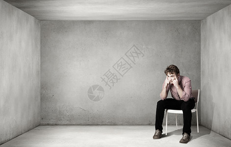 沮丧的人独自坐椅子上处于绝望之中图片