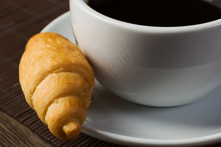 早餐茶托上的咖啡牛角包图片