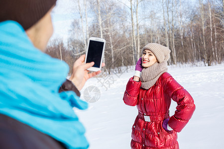 冬季公园散步冬天公园的轻人拍他女朋友的照片图片