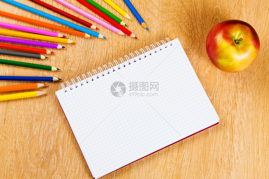 学校固定木制桌子上的彩色铅笔记事本图片