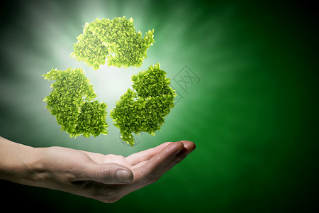 回收绿色紧握绿色回收标志的手背景图片