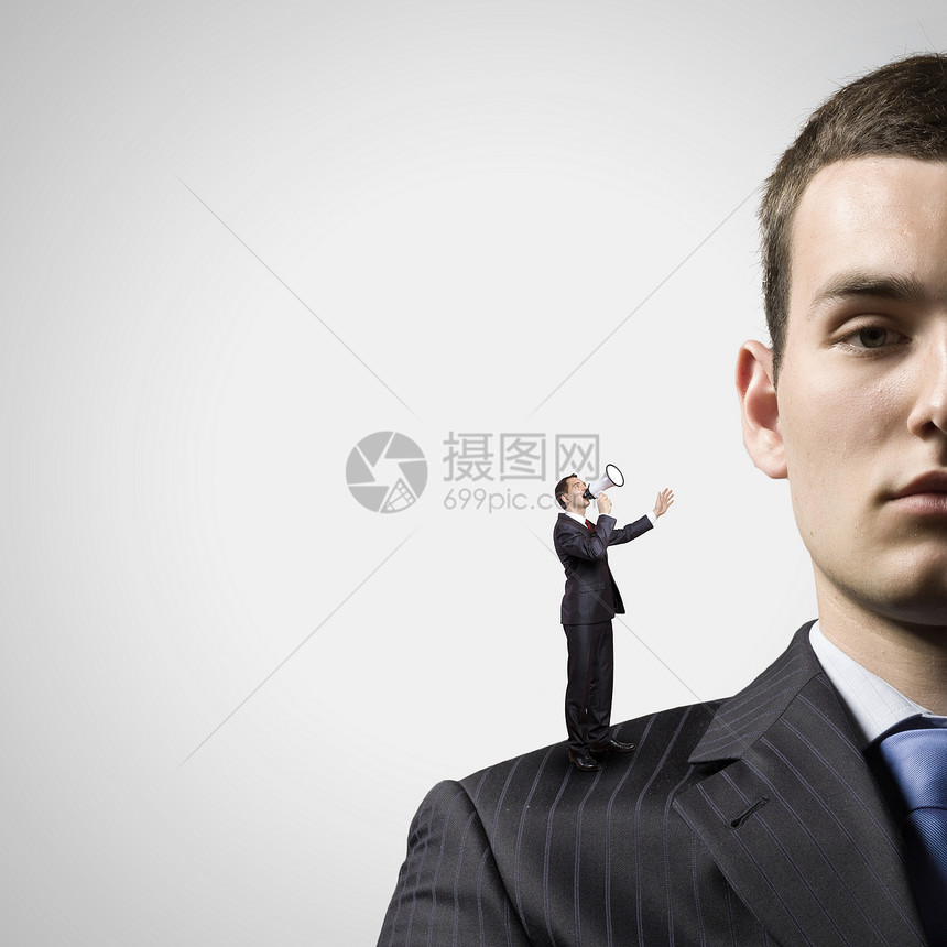 商业关系站老板肩膀上的商人用扩音器尖叫的缩影图片