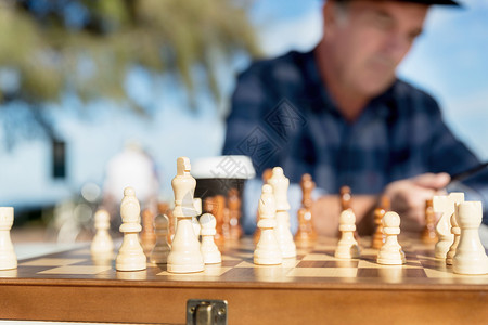 老人坐户外下棋思考国际象棋策略图片