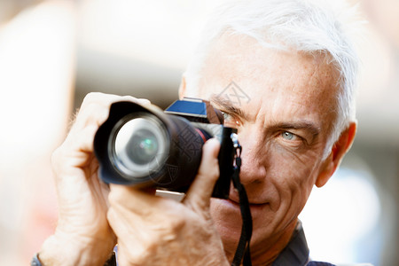 城市里带着相机的老男寻找好的拍摄角度高清图片