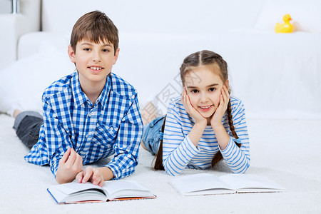 可爱的孩子看书学校男孩女孩躺地板上看书图片