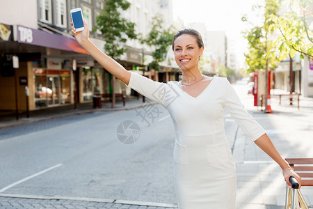 商务女士拉着手提箱袋城市里散步轻的商务女士带着手提箱城里找出租车图片