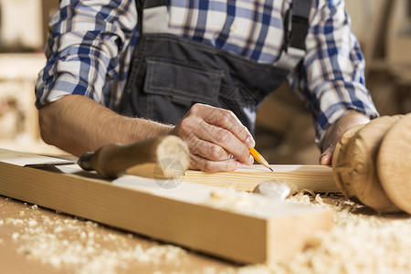 木工工人年轻的木匠在他的工作室里切割机工作背景
