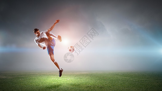 足球运动员击球体育场球的足球运动员背景图片