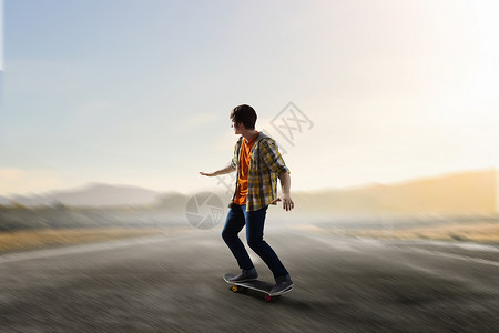 男孩骑滑板活跃的家伙骑滑板沥青路上背景图片