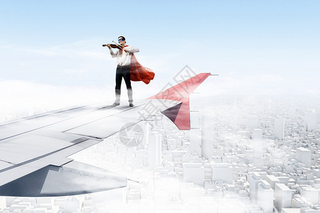 飞行飞机的机翼上轻的商人超级英雄飞机机翼边缘拉小提琴图片