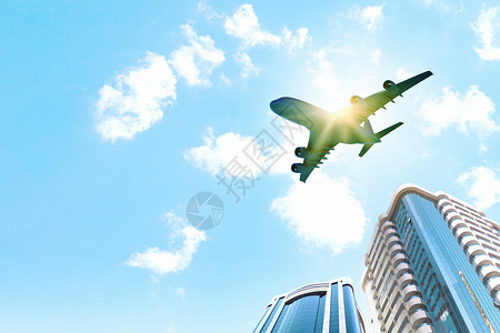 城市上空的飞机飞机飞过摩天大楼的图像底部视图图片