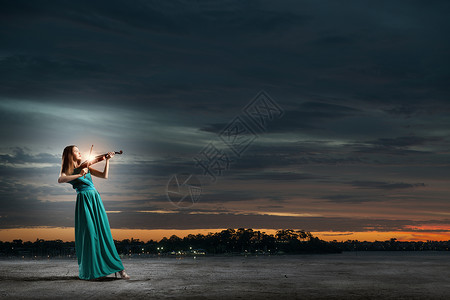 穿着绿色连衣裙的小提琴女演奏家吸引力的小提琴家图片