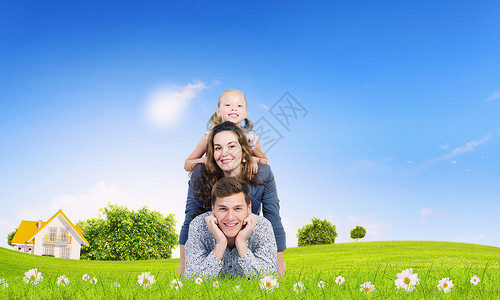 年轻的家庭幸福的三口之家躺绿色的草地上图片