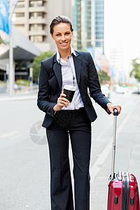 拉行李女商务女士拉着手提箱城市里散步轻的商务女士拉着手提箱城市里散步背景