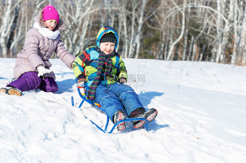 冬天的乐趣男孩女孩美丽的雪冬公园里享受雪橇图片