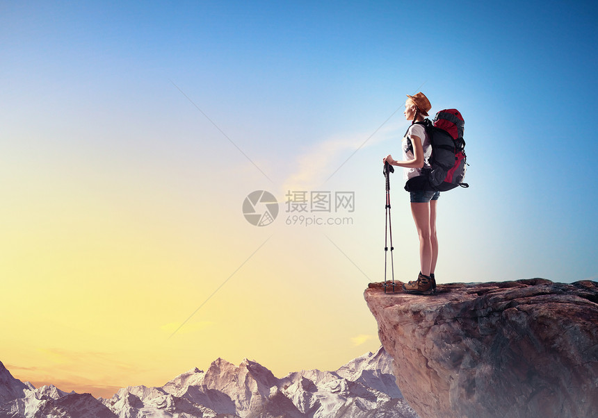 轻的女人登山者站山顶上的漂亮山顶上图片