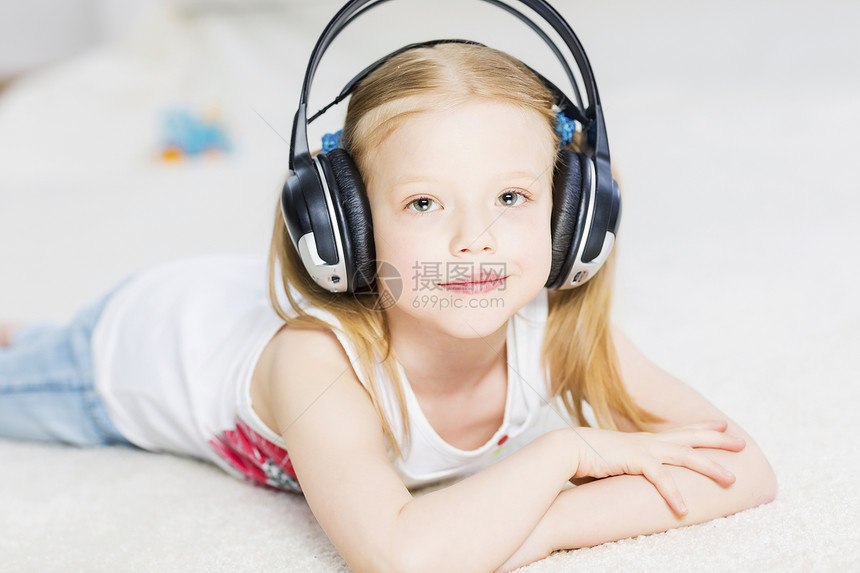 可爱的可爱女孩戴着耳机,享受音乐喜欢听音乐图片