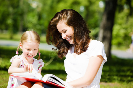 母亲和女儿看书可爱的女孩和妈妈公园玩耍的形象背景