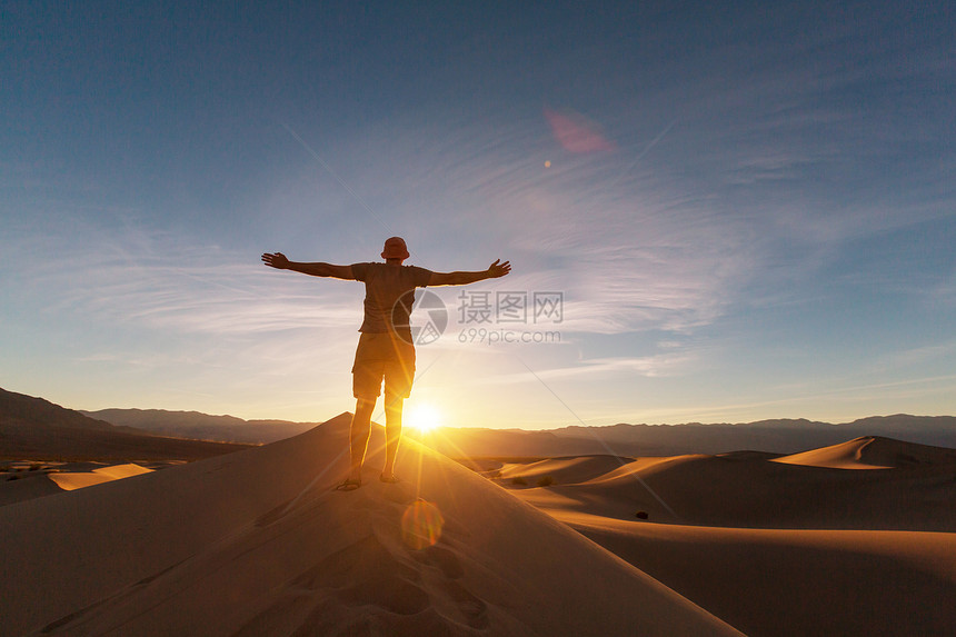 沙漠里的徒步旅行者日出时间图片