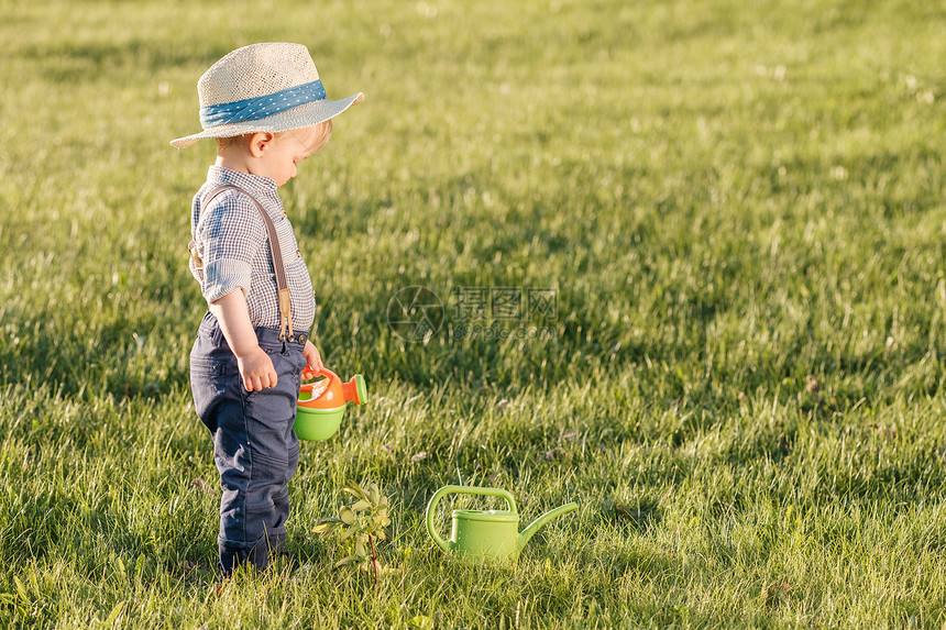户外幼儿的肖像农村场景岁小男孩戴草帽用浇水罐图片