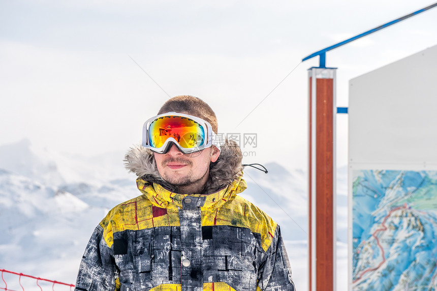 轻人户外戴着滑雪护目镜,背景上覆盖着法国阿尔卑斯山瓦尔drsquoIsere,法国图片