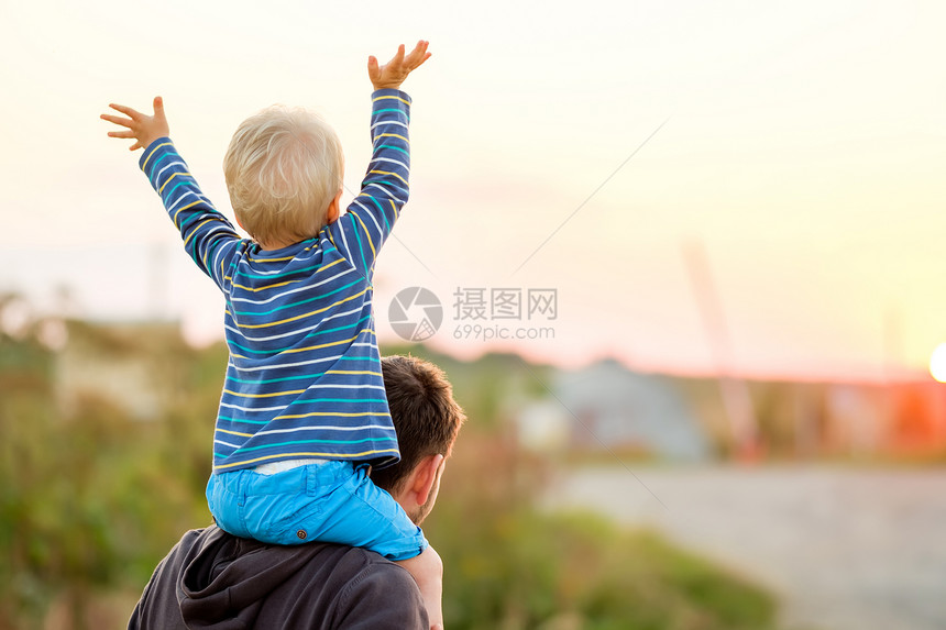 快乐的男人他的孩子户外玩得很开心家庭生活方式农村场景的父亲儿子夕阳的阳光下图片
