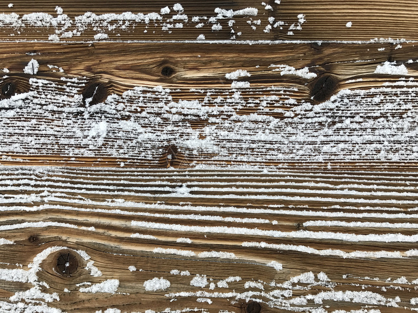 古老的木墙覆盖着雪,复古的自然户外背景图片