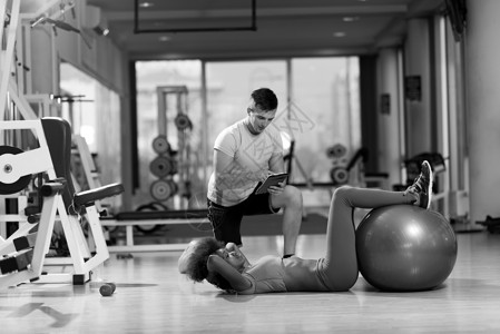 腓肠肌健康的轻夫妇健身房普拉提锻炼与私人教练背景