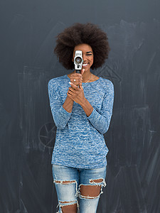 妇洗位轻美丽的非裔美国妇女用复古摄像机隔离灰色背景上背景