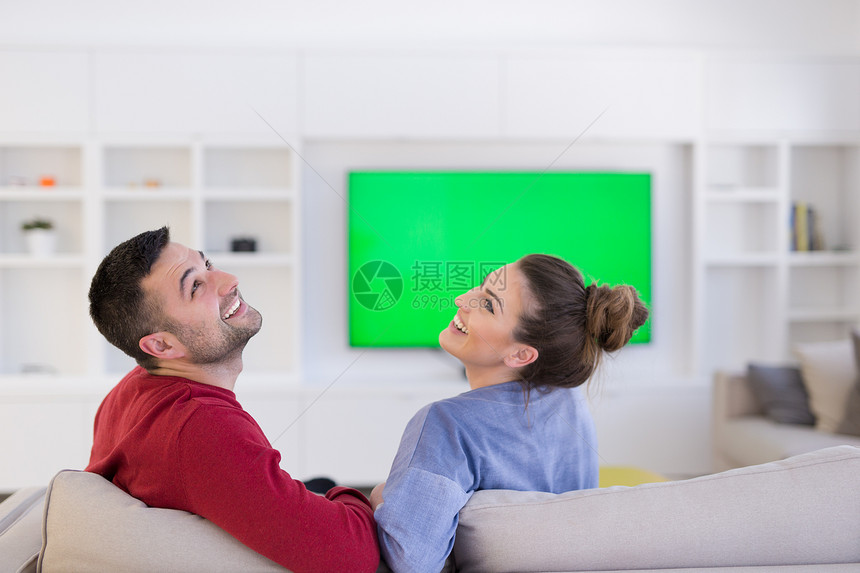 轻夫妇沙发上他们豪华的家看电视图片