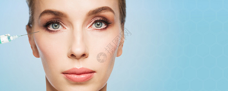 人,美容,整形,抗衰容美丽的轻女人的脸注射器注射眼睛区域的蓝色背景背景图片