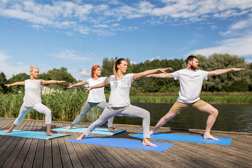 健身,运动健康的生活方式群人河边湖边的战士姿势瑜伽图片