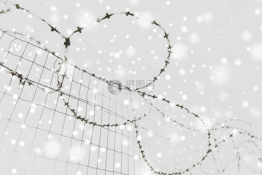 监禁限制灰色的天空雪地上竖铁丝网灰色的天空雪地上竖铁丝网图片